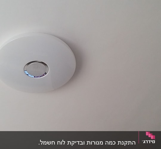 גלאי עשן עגול מותקן על תקרה לבנה